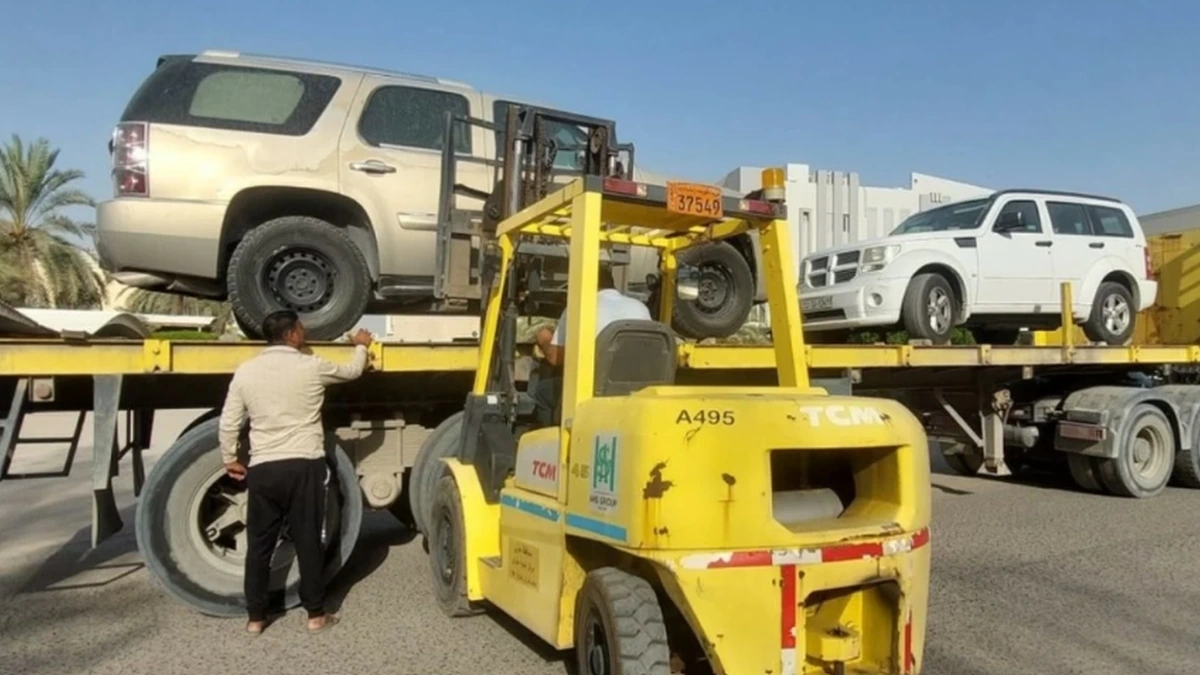 Kuwait municipality cleanup removing abandoned cars and boats with forklift