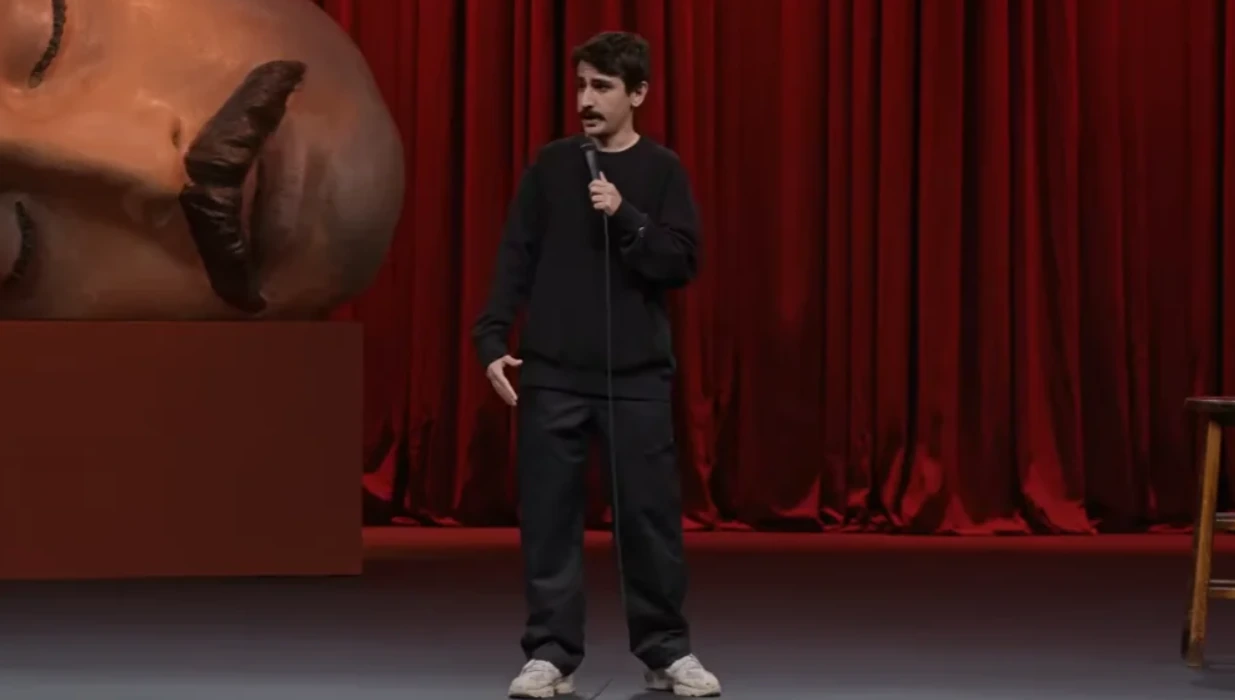 Turkish stand-up comedian Deniz Goktas performing on stage