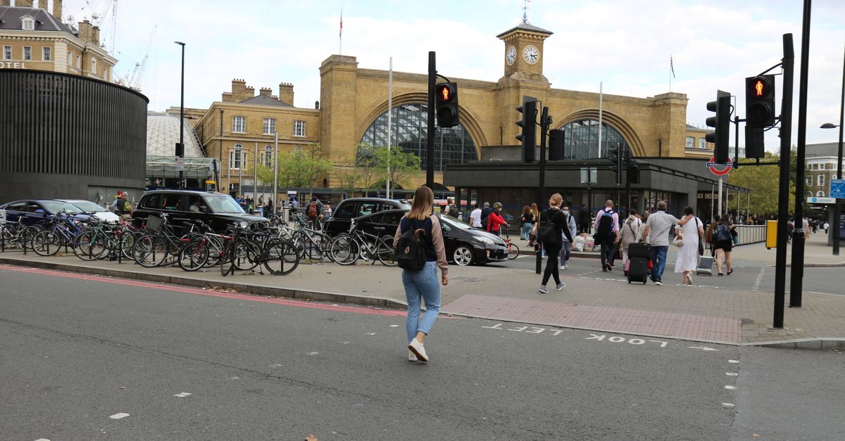 Pedestrians and traffic outside King's Cross Station, a bustling transport hub in London, England.