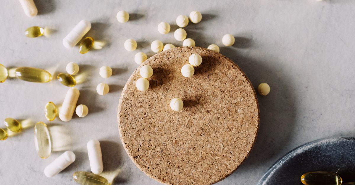Assorted pills and capsules on a marble surface, highlighting healthcare and medicine.