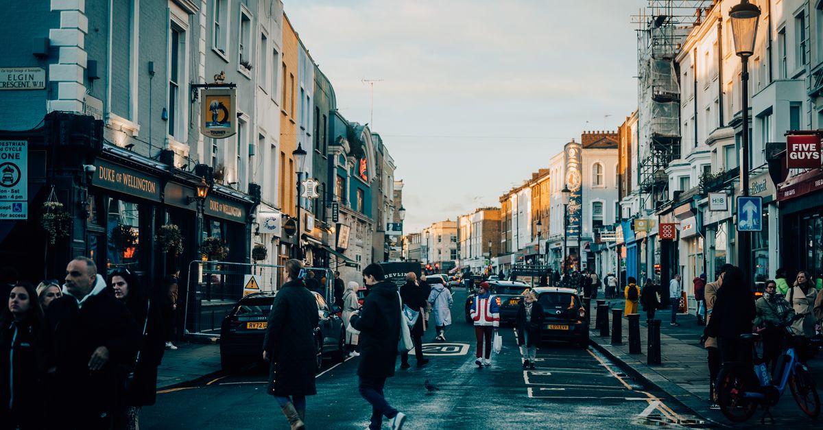 Busy street scene in Notting Hill, London with people and classic architecture.