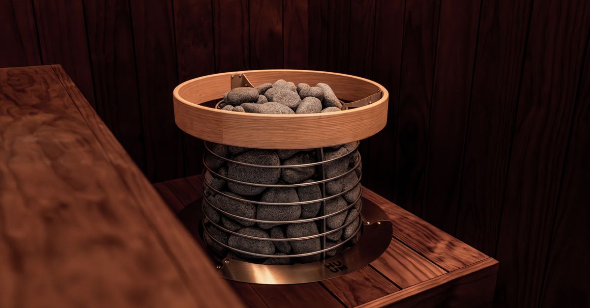 Stylish indoor sauna with a modern electric heater and natural wood design for relaxation.