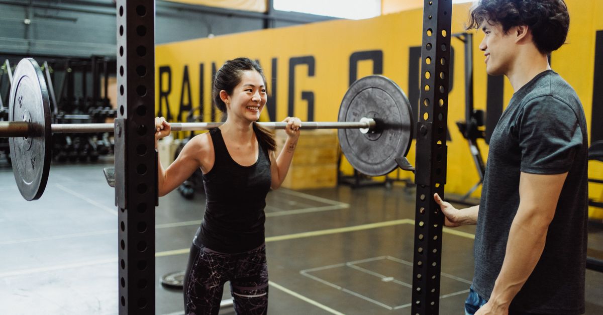 A couple working out together at the gym, weightlifting and enjoying an active lifestyle.