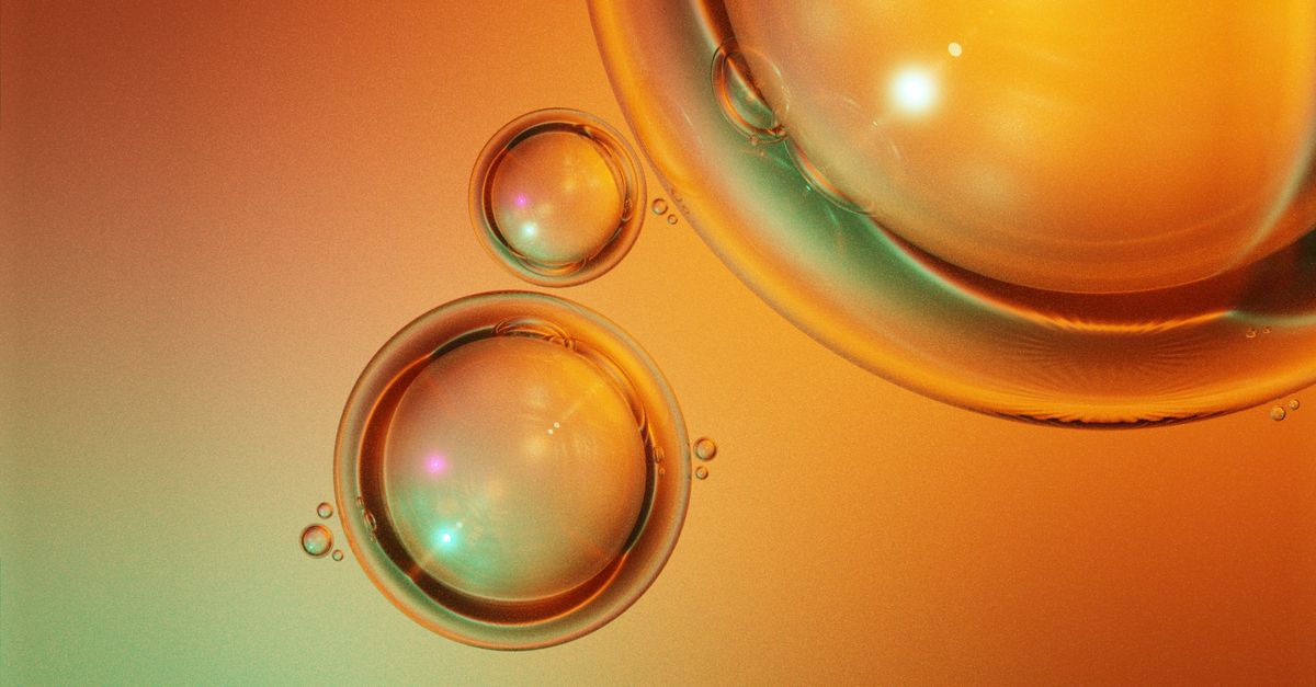 Close-up of vibrant orange bubbles on a colorful abstract background.