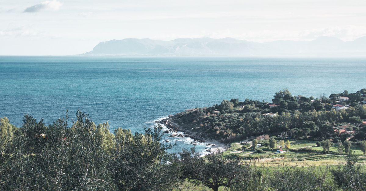 Breathtaking view of Zingaro Nature Reserve coastline in Sicily, Italy, under a clear summer sky.