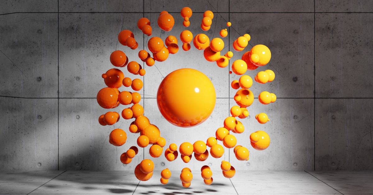 Dynamic display of floating orange spheres in geometric pattern within a modern concrete space.