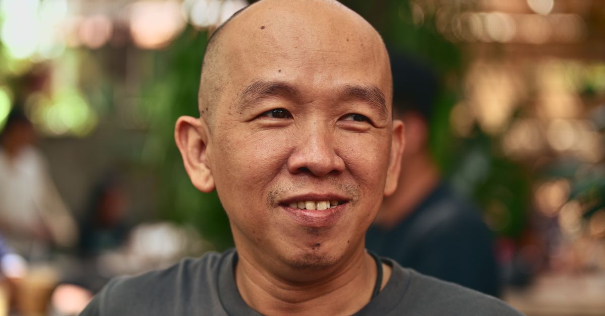 Smiling man enjoying a sunny day outdoors, exuding warmth and friendliness.