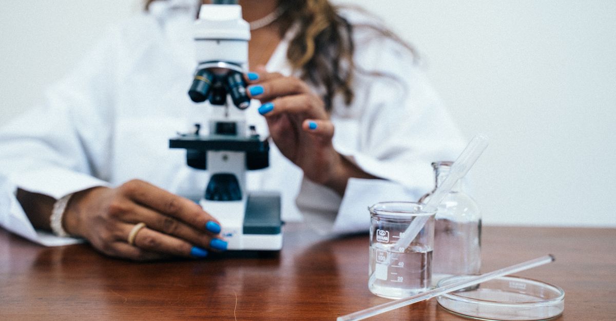A female scientist conducting research with a microscope and laboratory equipment.