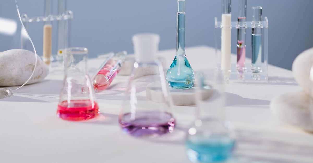 Vibrant liquids in glassware on a laboratory table in a modern science setting.
