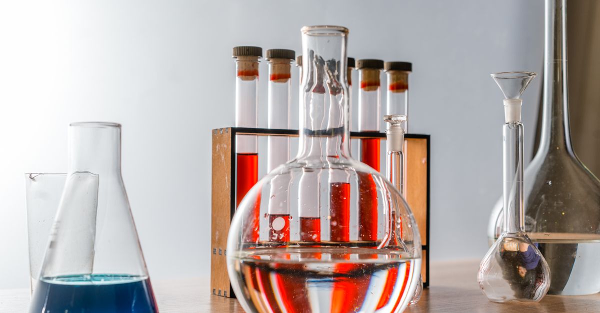Close-up of various glassware in a lab, highlighting colorful liquids in test tubes.