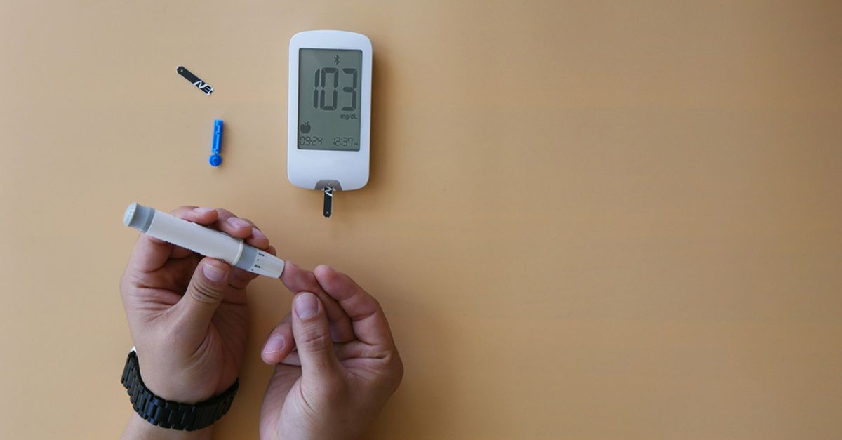 Close-up of a person using a glucose meter for blood sugar testing.