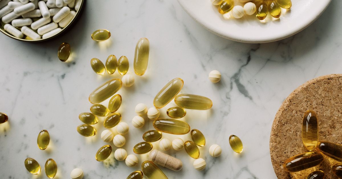 A collection of supplements and pills scattered on a marble surface, showcasing healthcare essentials.