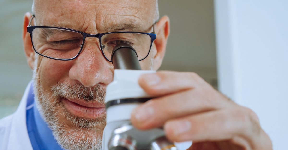 Close-up of a male scientist using a microscope in a laboratory.