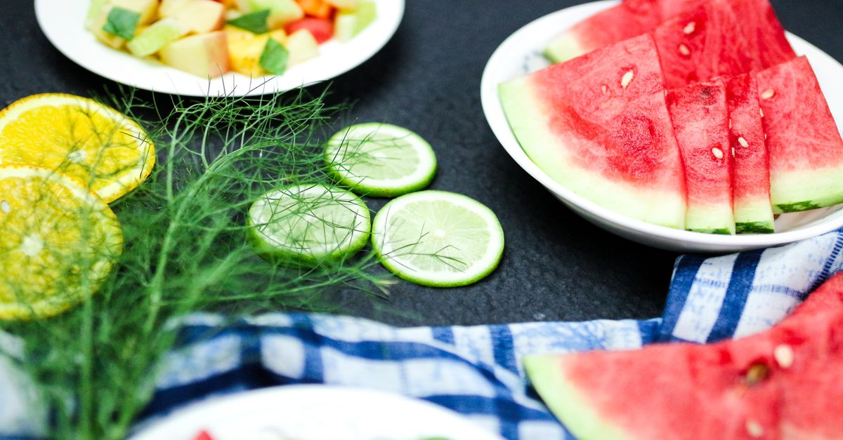 Bright and colorful summer fruit platter with watermelon slices, citrus, and other fresh fruits on a table.