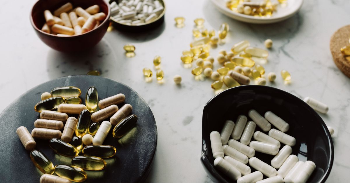 From above of varied medical capsules and tablets sorted into different dishes for treatment on marble table in hospital