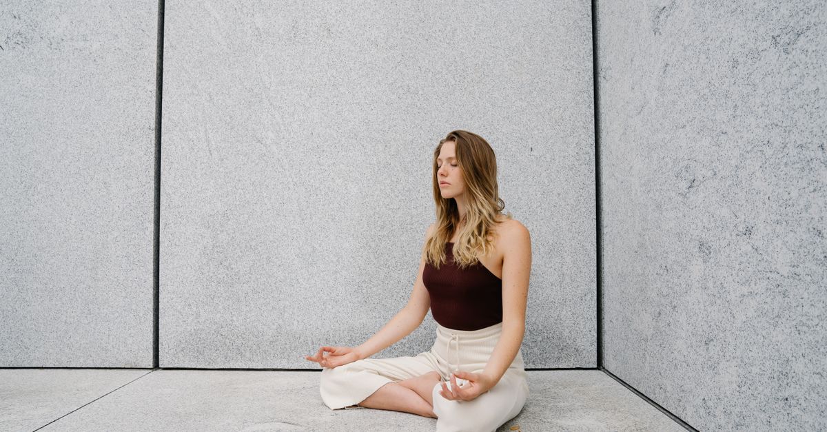 Young woman practicing yoga meditation indoors with calm expression and peaceful atmosphere.