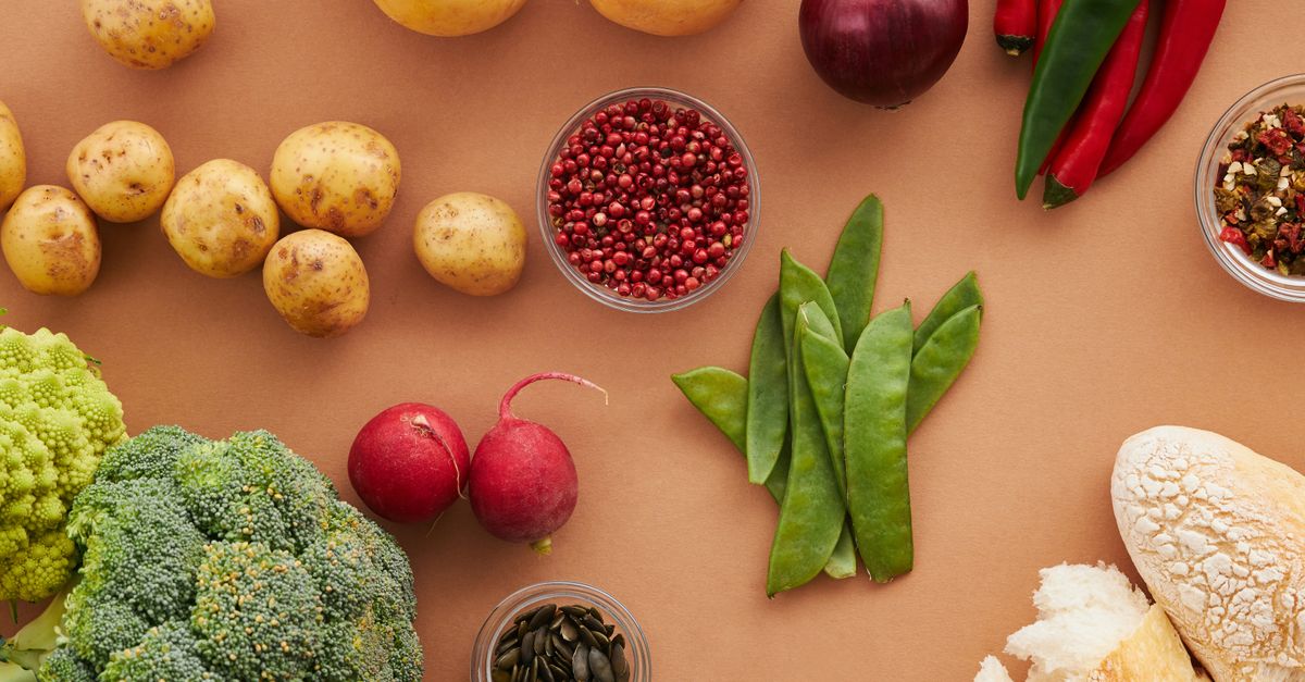 Top view of fresh ingredients including vegetables and bread, ideal for healthy cooking concepts.
