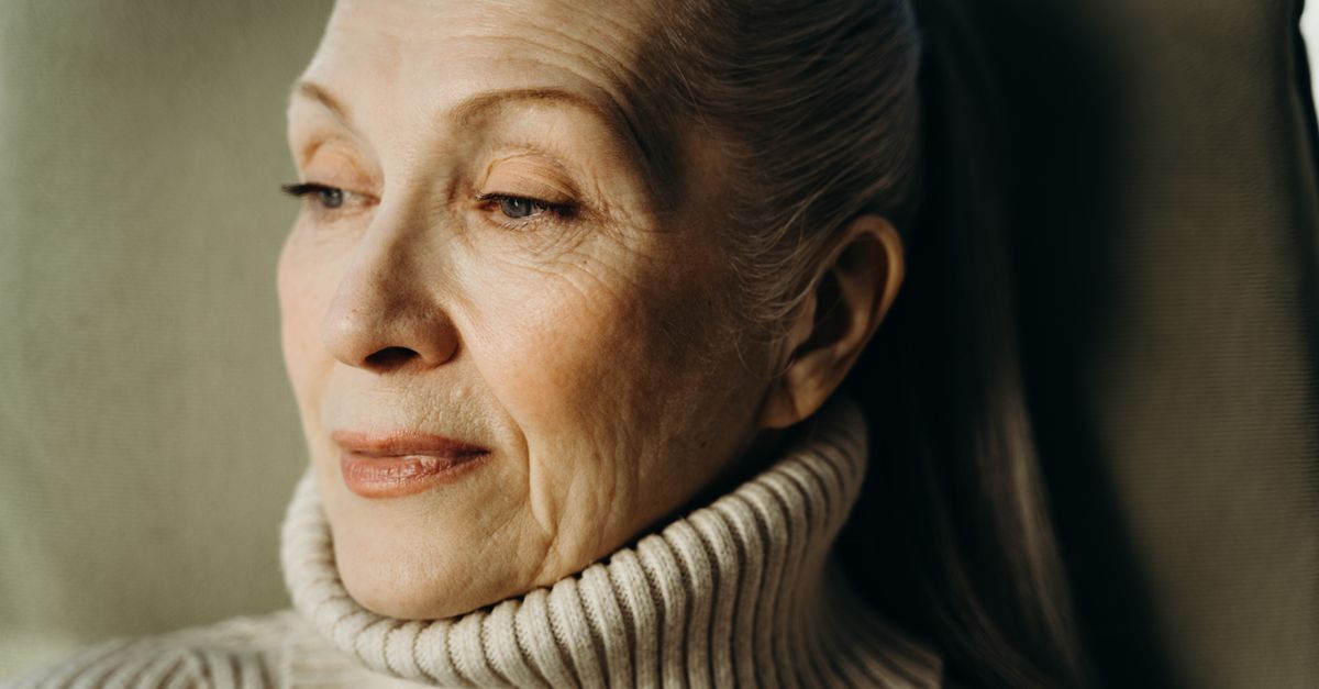 Close-up of a thoughtful senior woman wearing a cozy turtleneck sweater.