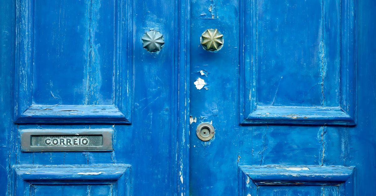 Rustic blue door featuring vintage mail slot 'Correio' and textured details.