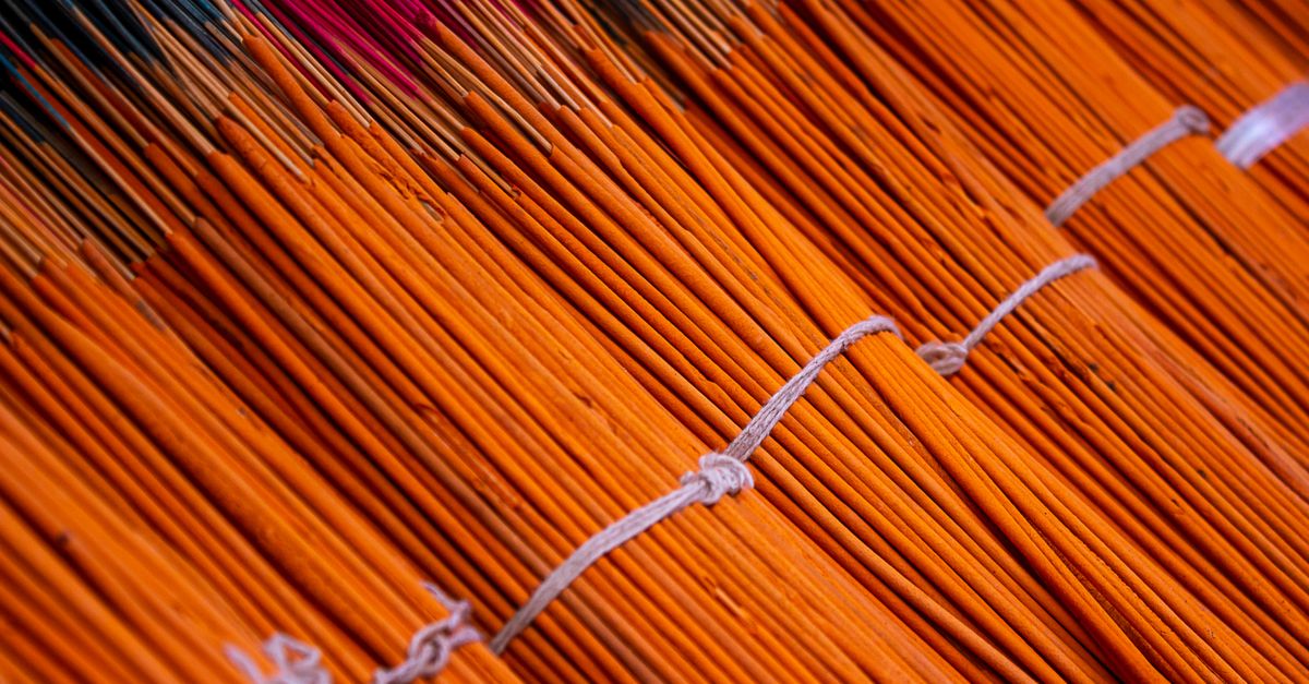 Close-up view of colorful bundled incense sticks arranged in neat rows for sale or display.