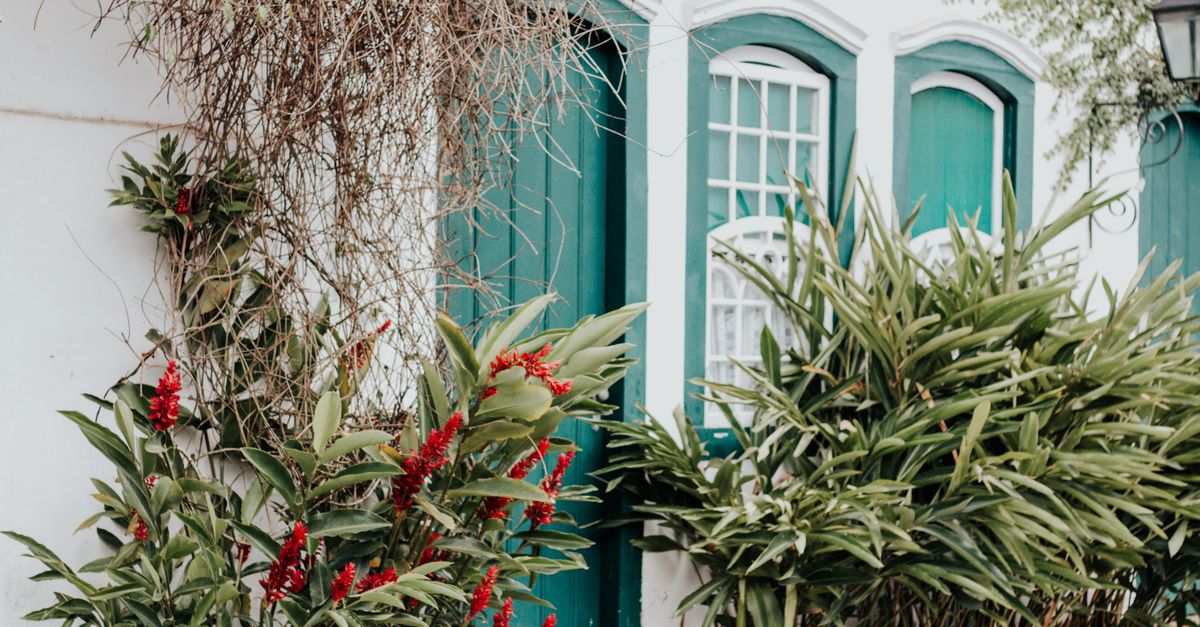 Colonial-style house with green windows and lush garden, Chácara da Saudade, Brazil.
