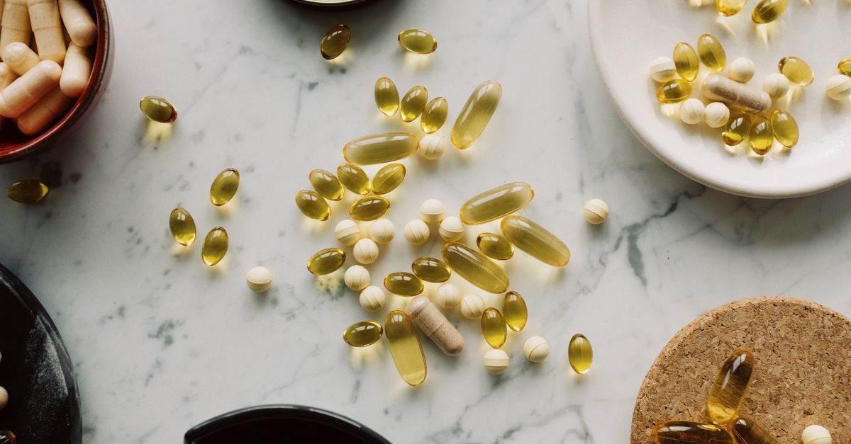 A top view of assorted capsules and pills displayed on a marble surface, showcasing a variety of medicines.