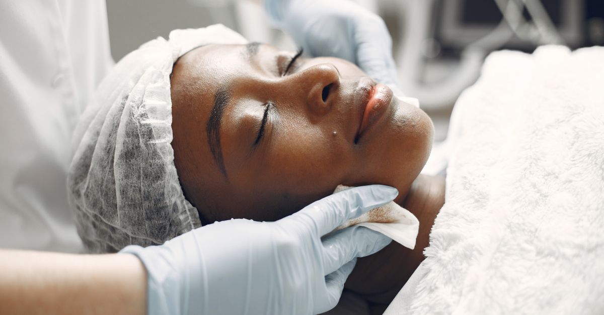 A woman enjoying a calming facial treatment at a spa, promoting relaxation and rejuvenation.