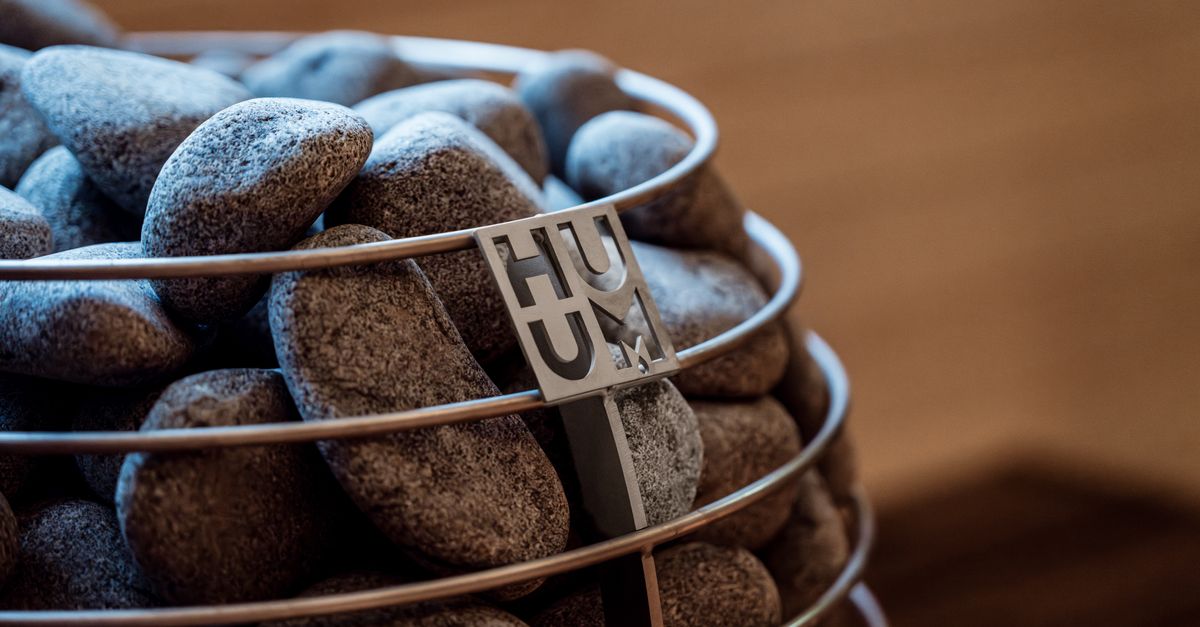 Close-up of a modern sauna heater filled with stones, showcasing Nordic design elements.