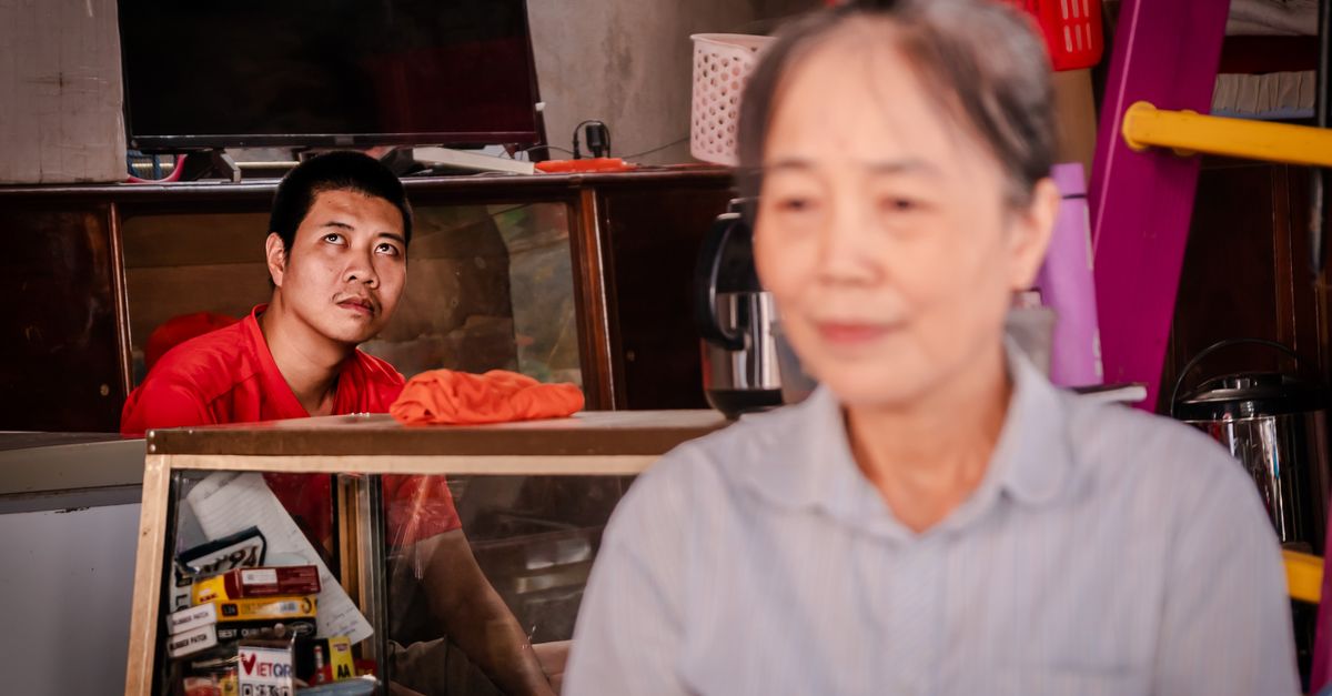 A man and woman in a local shop setting in Lào Cai, Vietnam, capturing daily life.