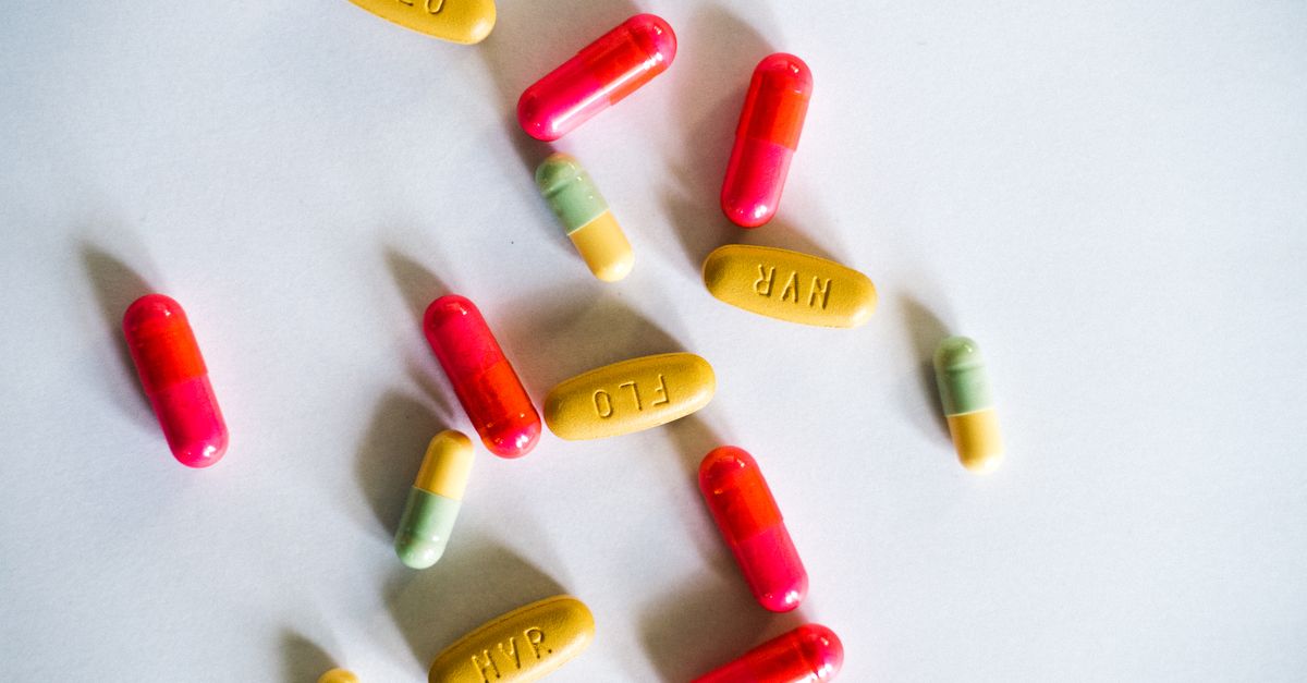 A vibrant assortment of colorful capsules and pills scattered on a white surface.