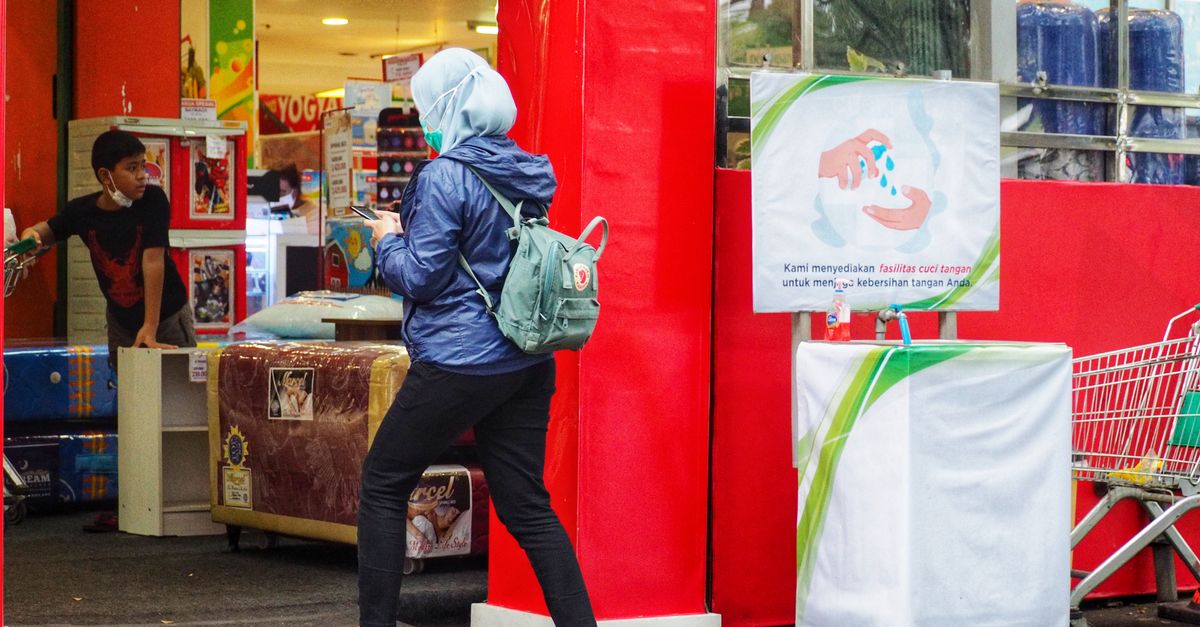 A woman wearing a hijab shops at a market in West Java, Indonesia, during the day.