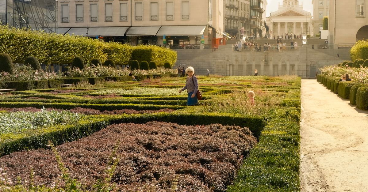 A peaceful scene in Brussels gardens with a historic building in the background.