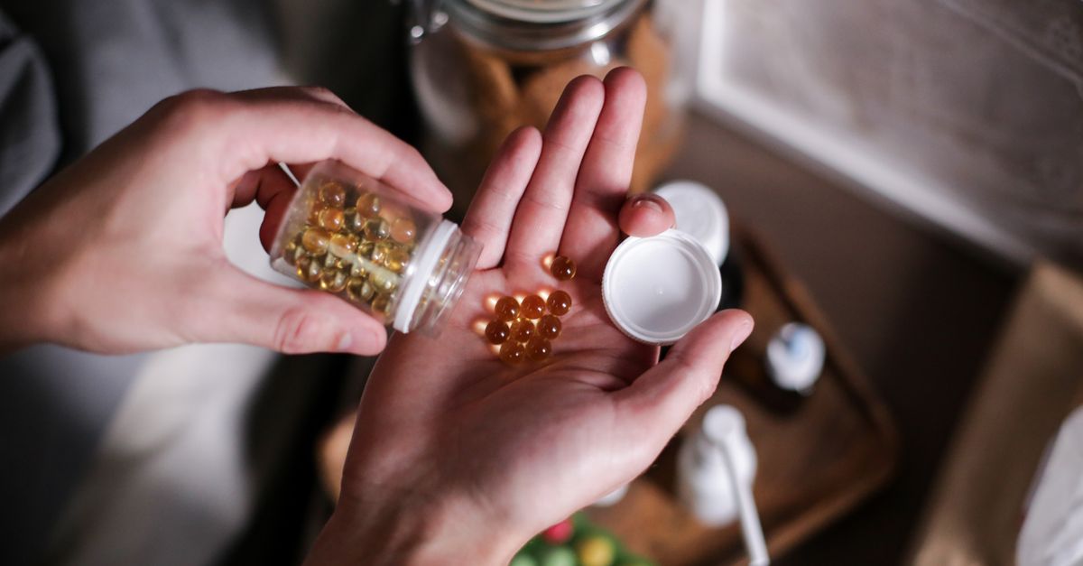 Hands carefully holding supplement capsules, representing health and wellness.