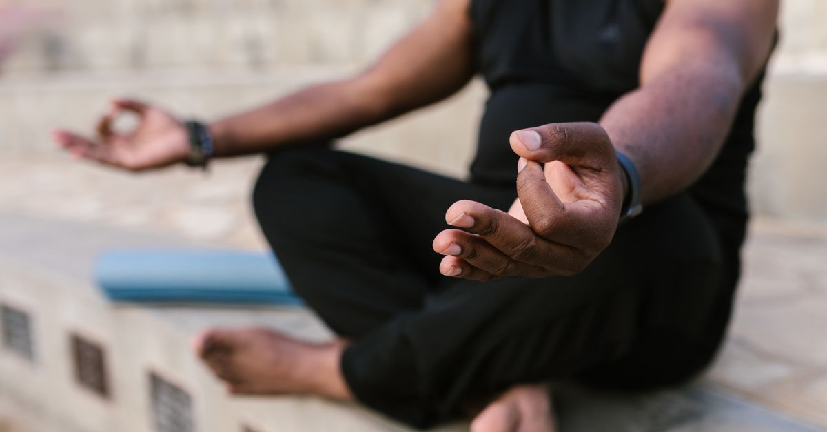 A man meditating and practicing yoga outdoors, focusing on mindfulness.
