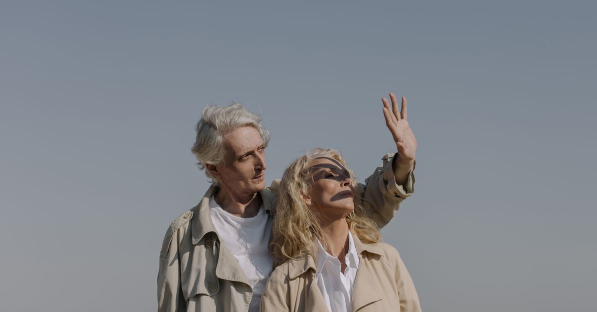 Stylish senior couple on a sunny beach enjoying a peaceful moment together.