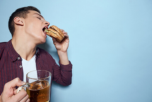 pictorial representation of a boy eating and drinking the worst things which cause colon cancer