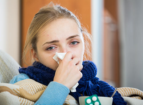 image of a girl sitting at home suffering from enlarged tonsils