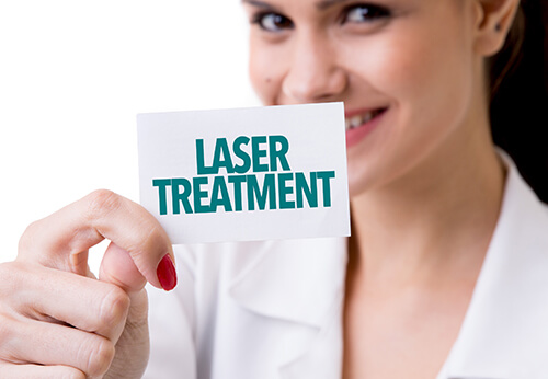 gynecologist holding a white card with "laser treatment" written on it