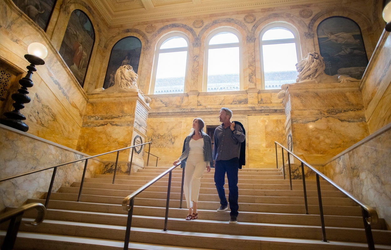 Couple walking down the stairs in Boston public library