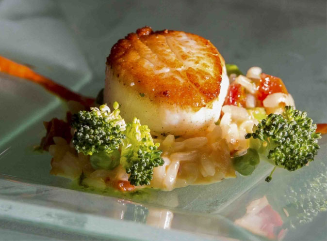 Scallop on top of rice mixed with vegetables