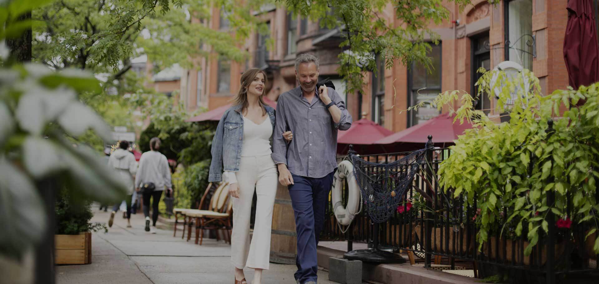 Couple walking in street full of restaurants