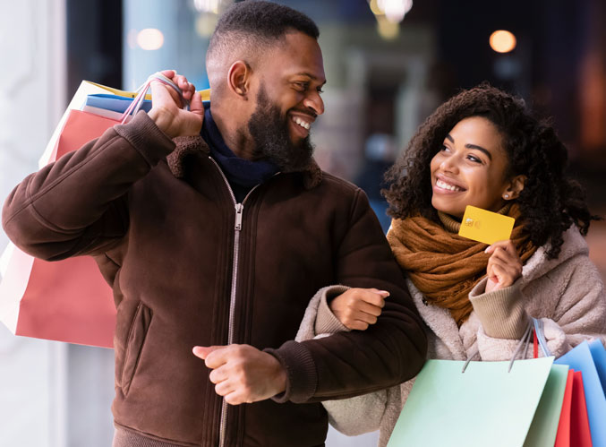 Couple shopping, holding gift cards