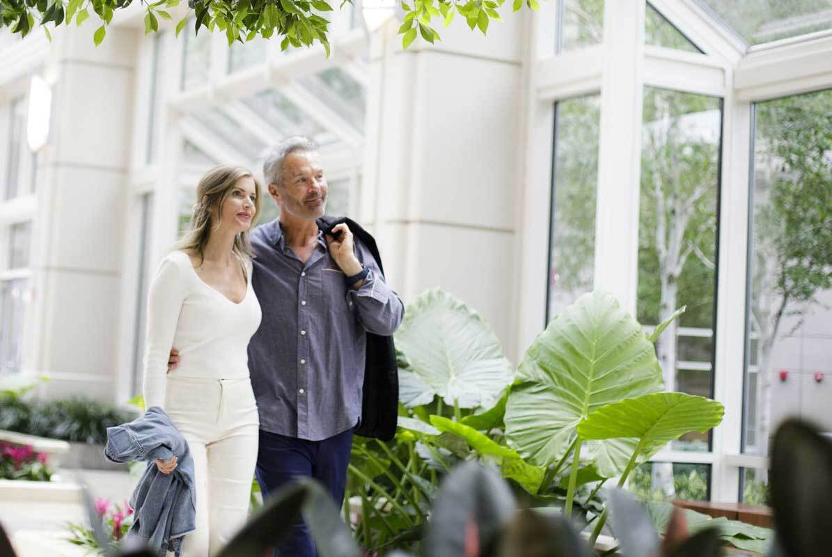 Couple walking in a room with plants
