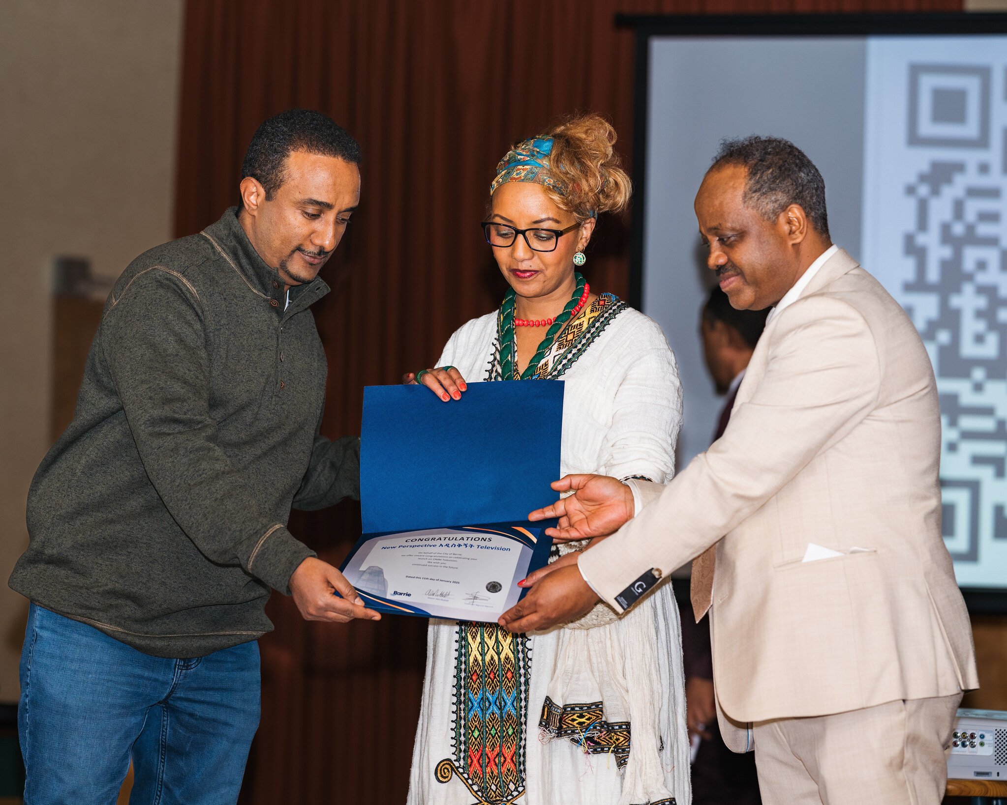Councilor Nigussie nigussie handing certificate to New Perspective tv founders and producers