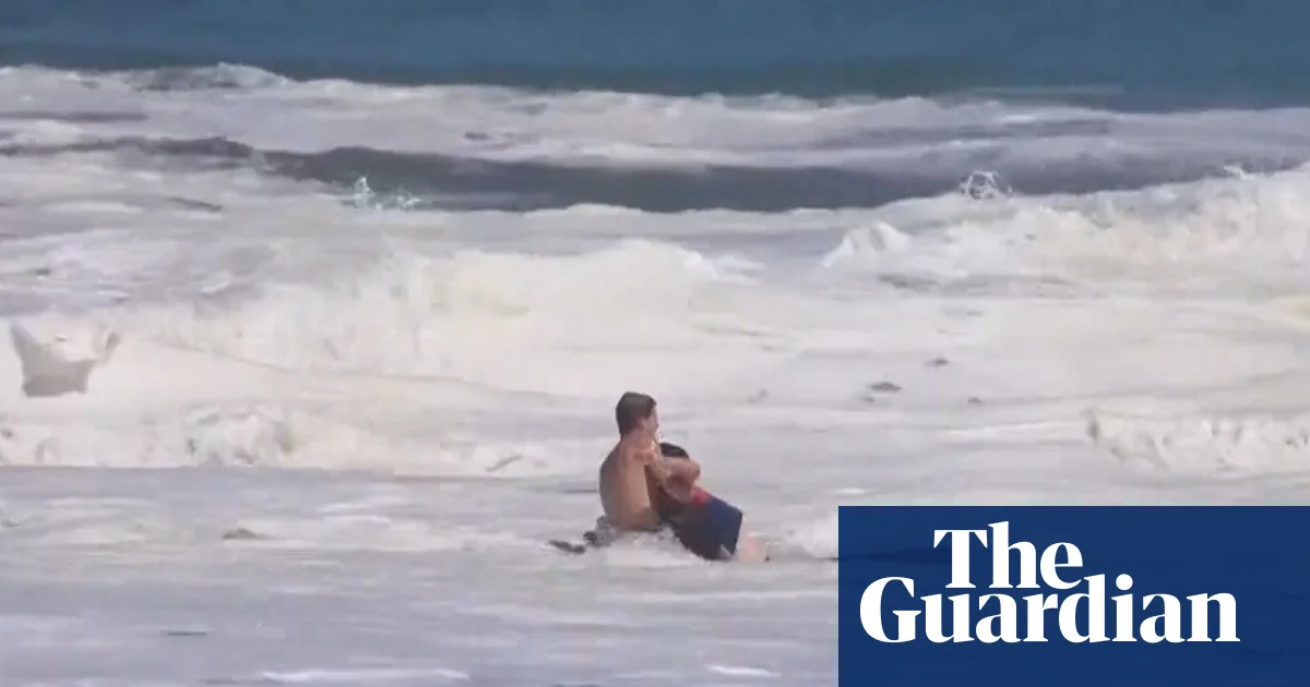 Teen lifeguard struggles to save boy from massive waves in California - video