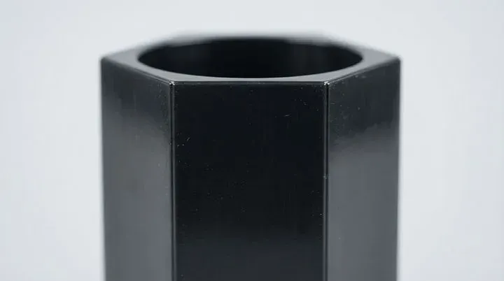 Close up view of hexagonal tube surface showing smooth glossy finish