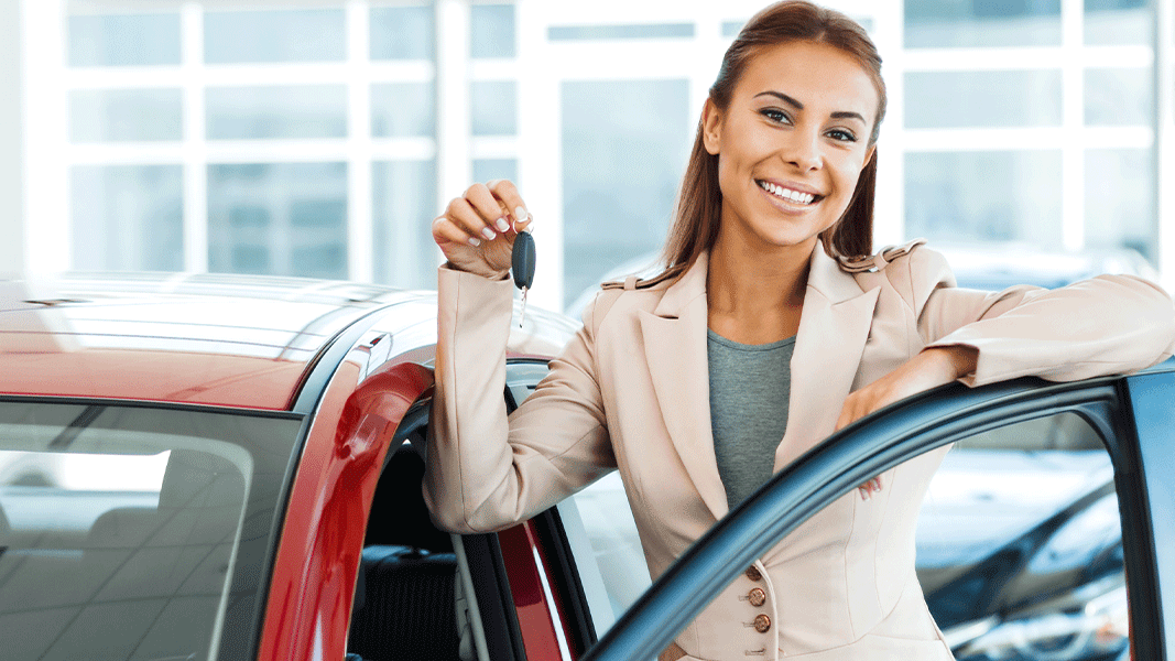 Vue d'une femme et nouvelle cliente ouvrant sa nouvelle portière d'auto, en financement Nissan