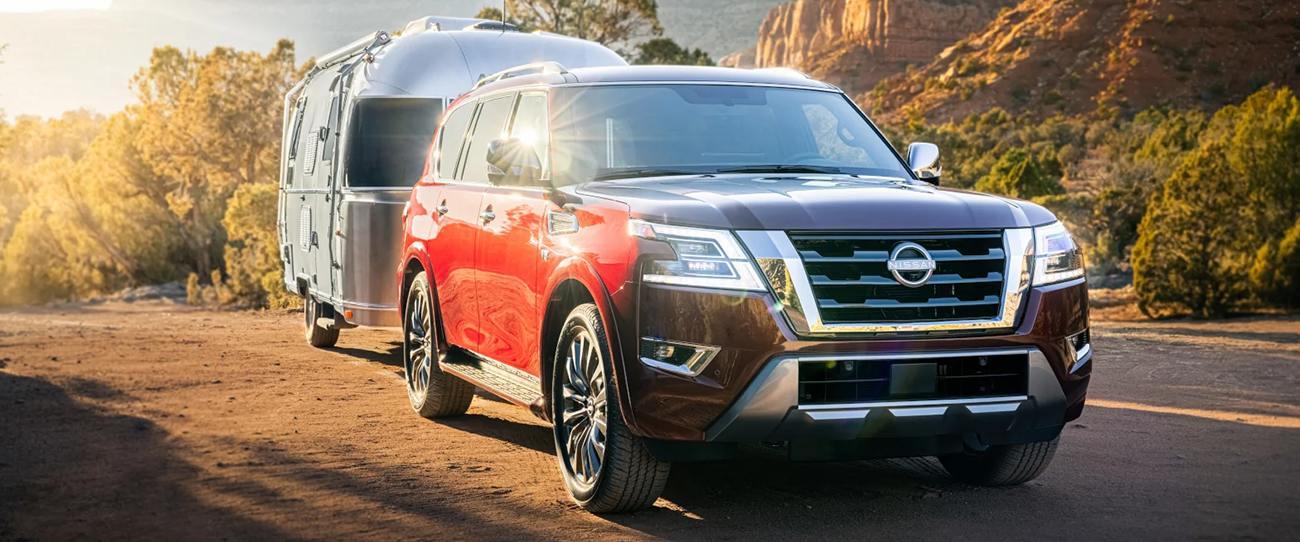 Vue 3/4 avant et latérale du Nissan Pathfinder 2025 sur route tractant une remorque
