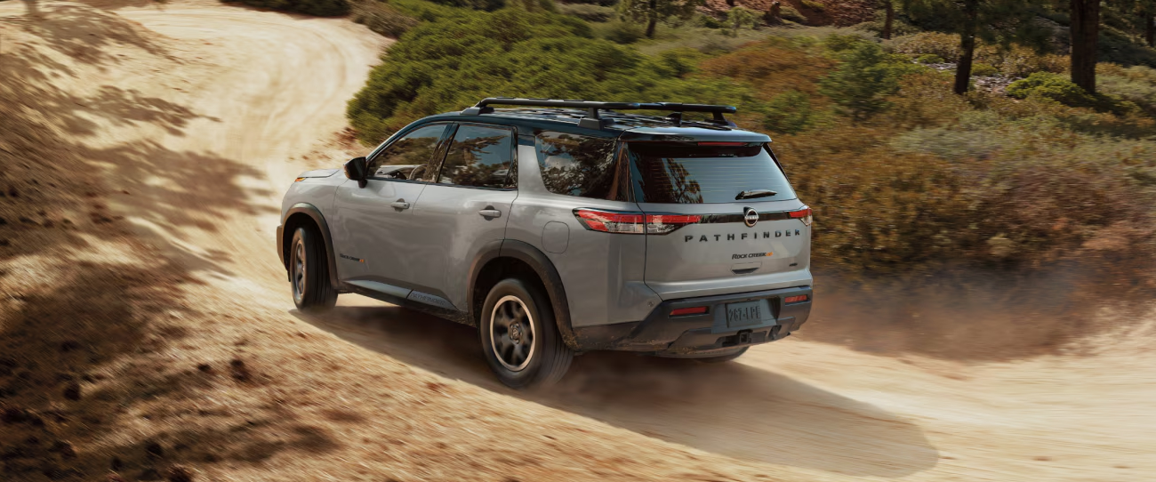 Vue arrière du Nissan Pathfinder 2025 sur route de sable en pleine puissance