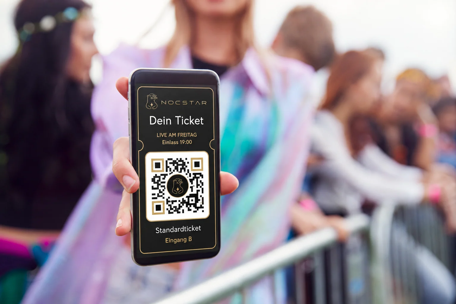 Eine Person hält am Festivaleinlass ein Smartphone mit einer Ticketansicht im Nocstar-Design.